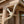 Close-up of a natural wood gazebo or pergola corner with a decorative curved bracket support and lattice paneling.