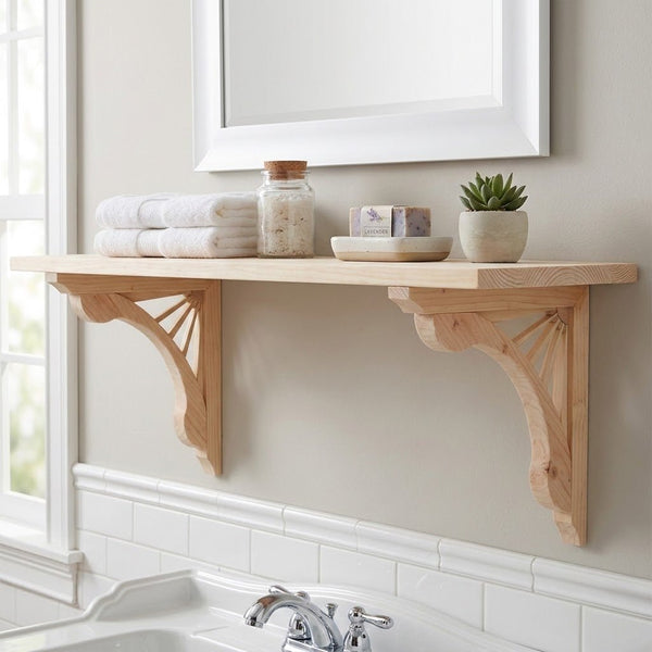 A light natural wood bathroom shelf mounted on a beige wall above a white tub, styled with folded white towels, a glass jar, soap bars, and a small potted succulent.